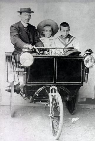Early three-wheeled motor vehicle with passengers